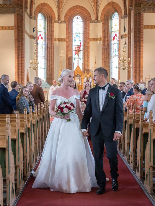 Bröllopsfotograf Linköping fotograferar brudparet vid utmarschen efter vigseln